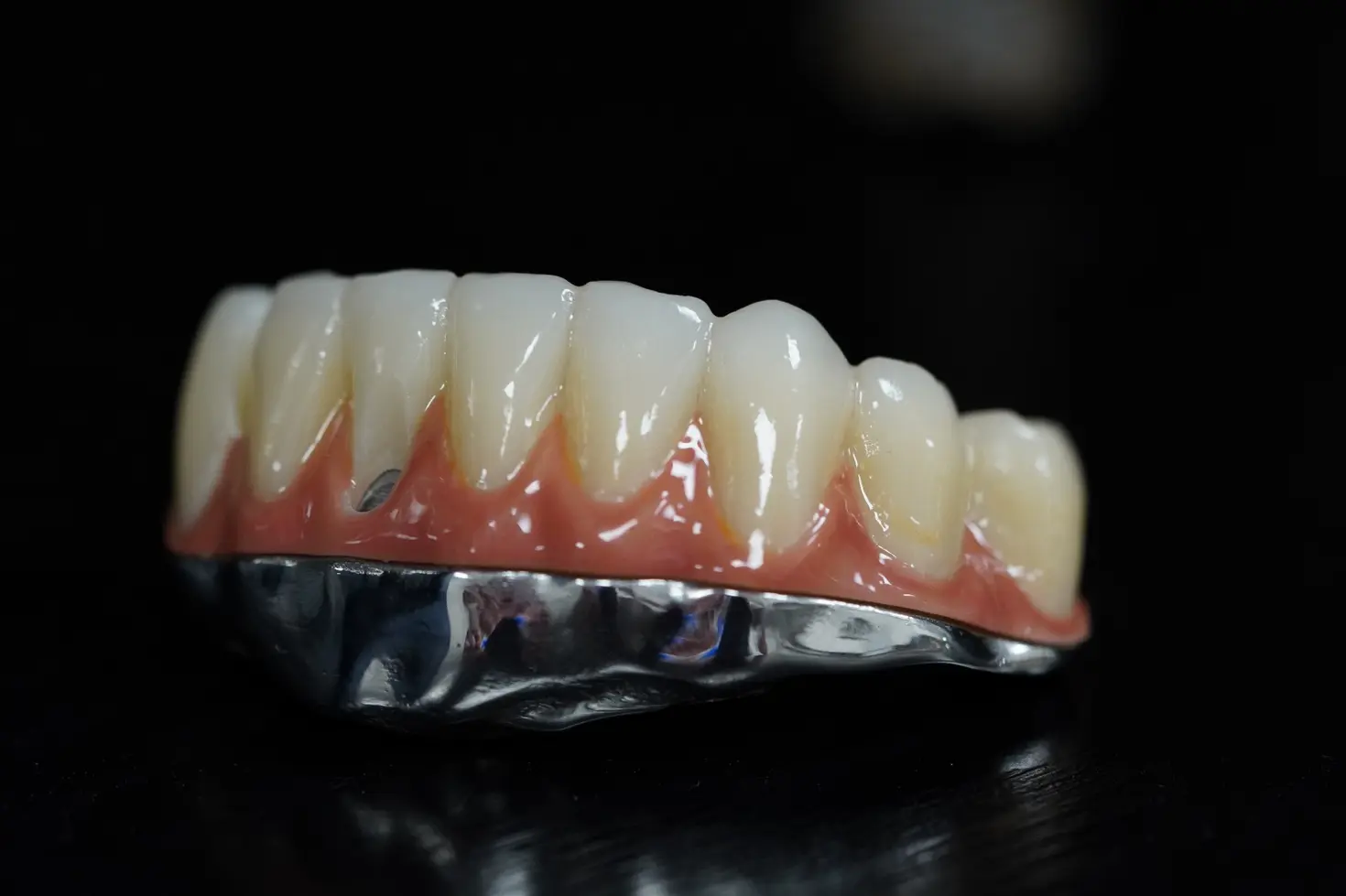 Barra metálica pulida con cilindros para implantes dentales